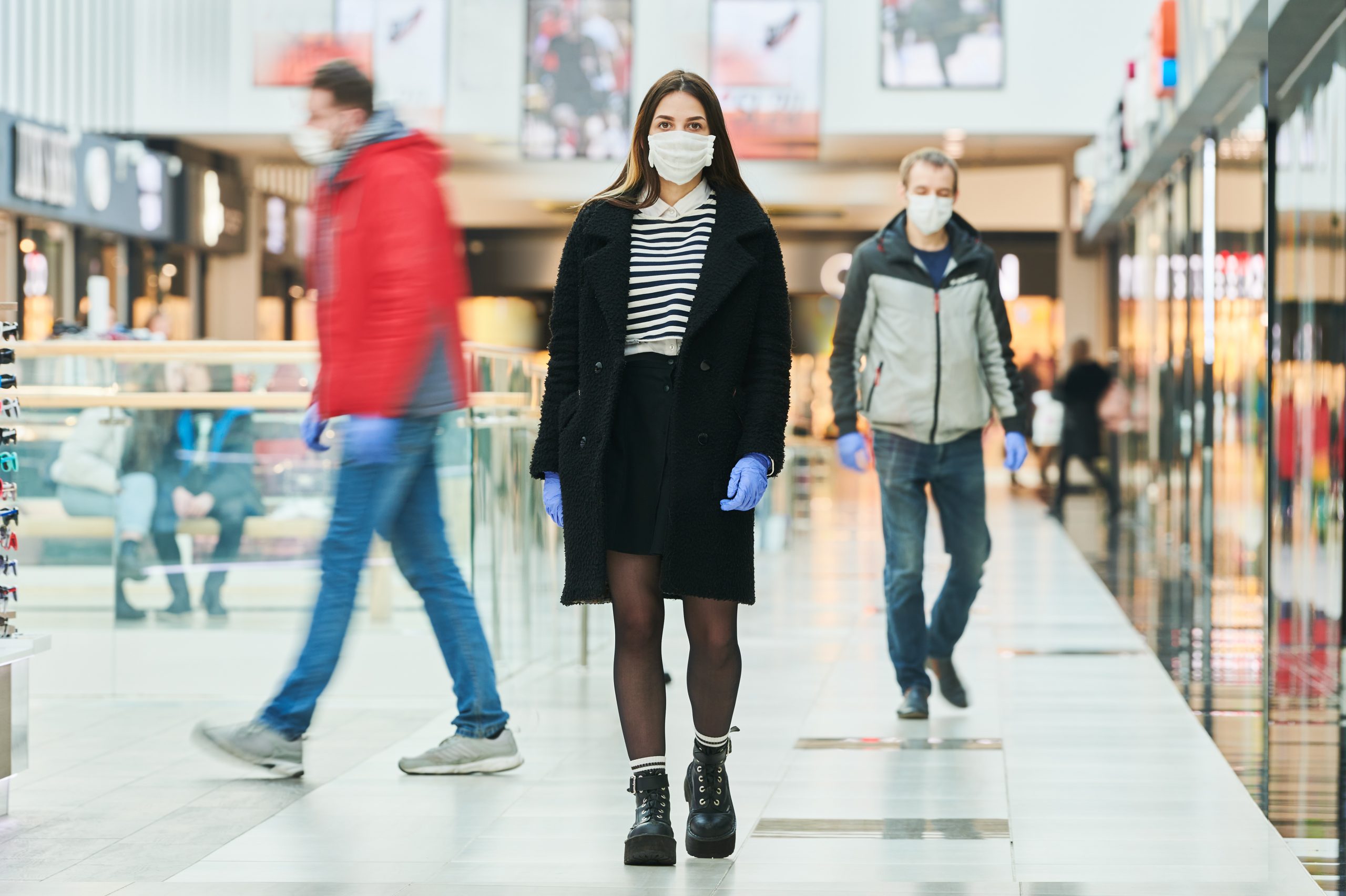 Menschen mit Gesichtsmasken gehen durch Flughafen