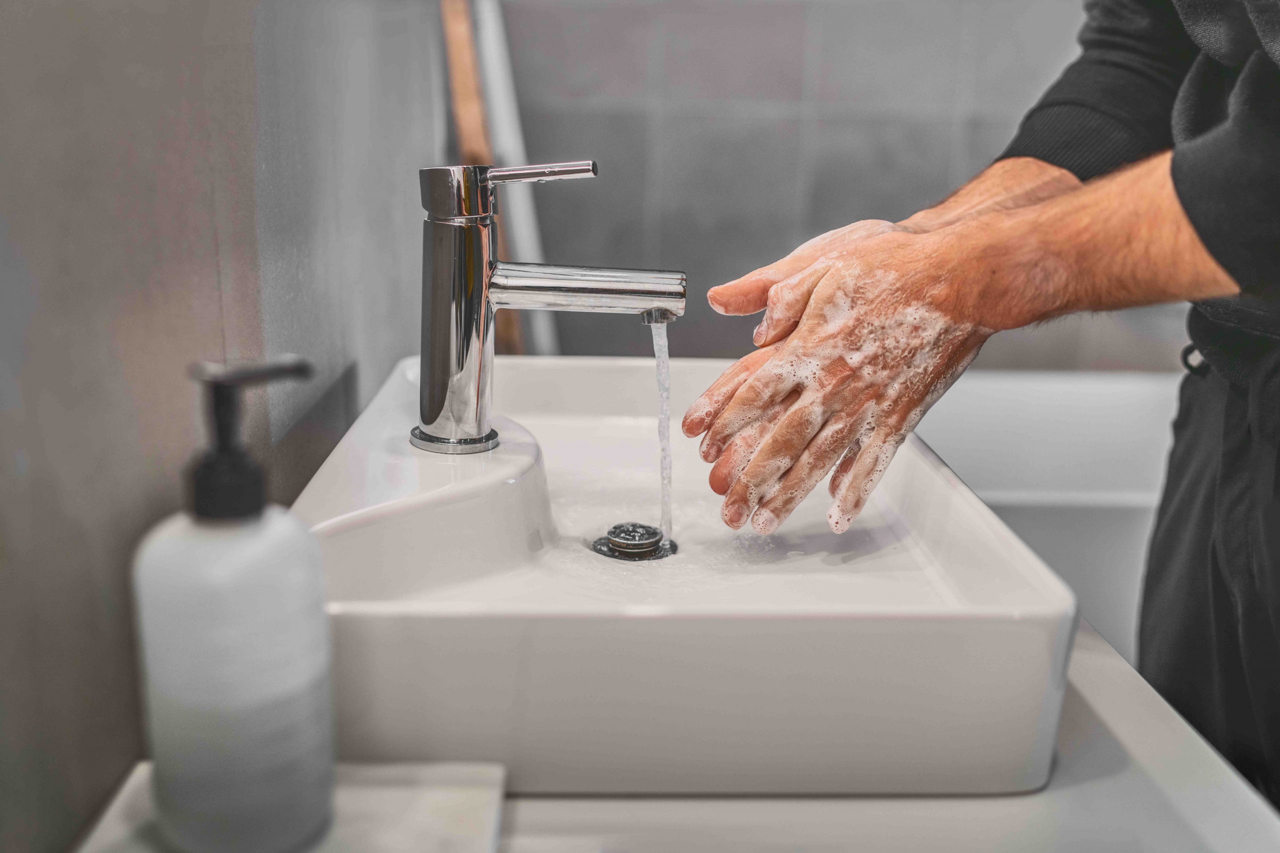 Person wascht Hände im Waschbecken